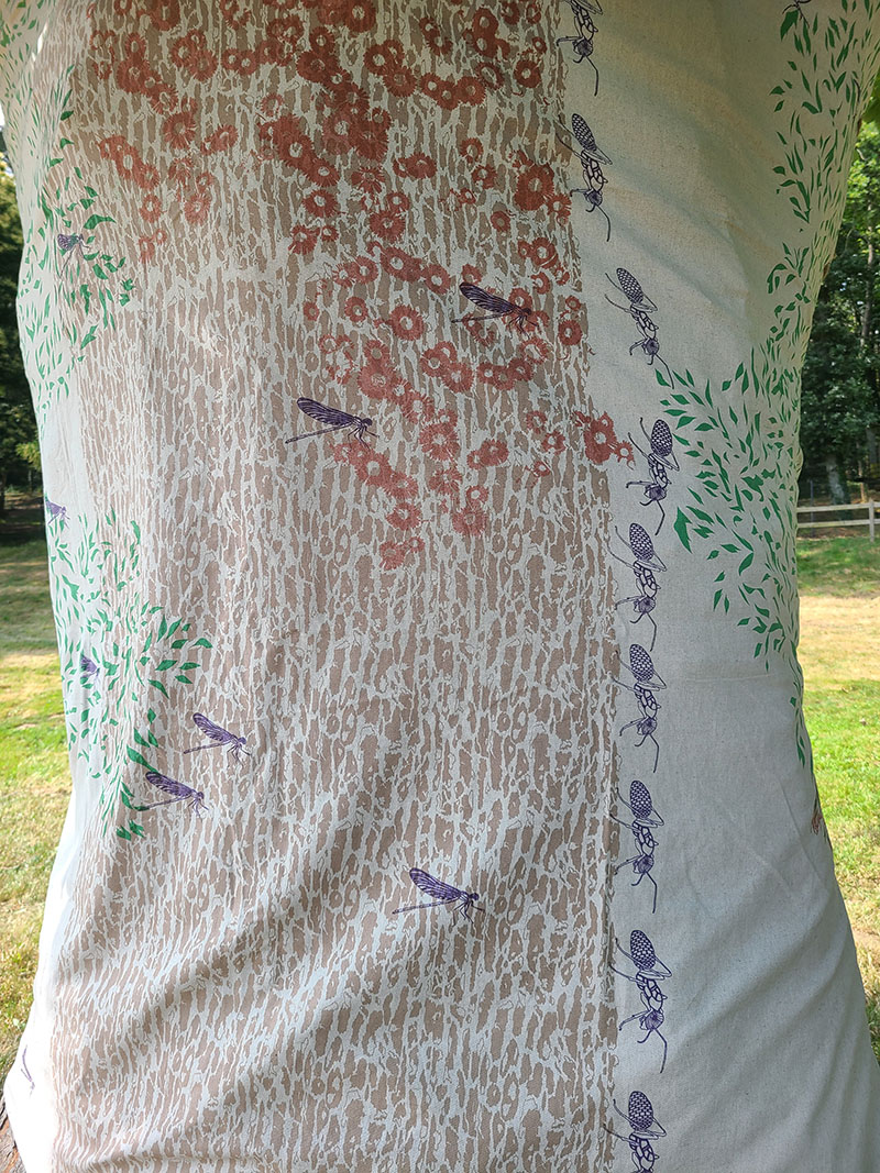 Habillage d'arbre par du tissu sérigraphié montrant la vie dans les arbres.